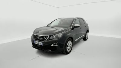 Une voiture noire est garée dans une pièce blanche