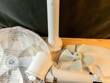 un rouleau de papier toilette blanc, une brosse de toilettes et un rouleau de papier toilette posés sur une table en bois