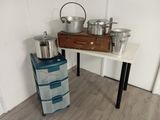 une table sur laquelle sont posés des casseroles et des poêles