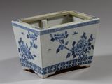 une jardinière bleue et blanche ornée de fleurs