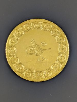 Gros plan sur une pièce d'or ornée d'un oiseau