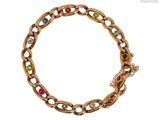 un gros plan d'un bracelet en or orné de pierres multicolores sur fond blanc
