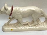 a figurine of a white dog with a red collar