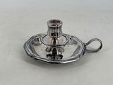 a silver plate with a silver candle holder on it