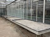 a long table in the middle of a large greenhouse