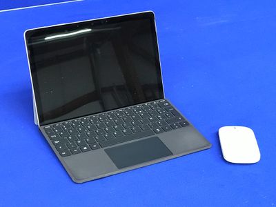 un ordinateur portable et une souris posés sur une table bleue