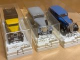 quatre voitures jouets dans une vitrine sur une table