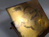 brass plate with a picture of a turtle on it on a stand