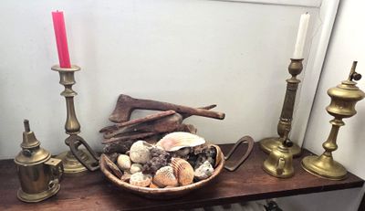 un panier de coquillages posé sur une table à côté d'une bougie
