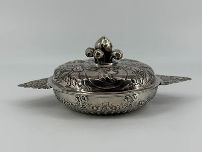 a silver plate with a lid that has a bird on it