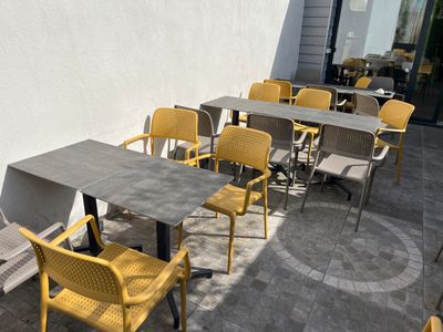 Des tables et des chaises sont alignées devant un restaurant
