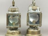 pair of antique brass lantern lamps on pedestals on a gray background