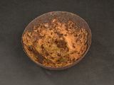 a rusted bowl sitting on a black surface