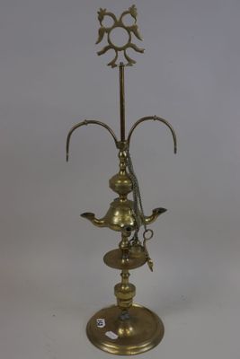 an antique brass oil lamp with a bird on top of it