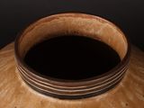 a brown vase with a brown rim sitting on a table