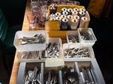 several trays of silverware on a wooden table in front of a window