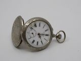 a silver pocket watch with roman numerals on it