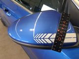 a measuring tape on the side mirror of a blue car