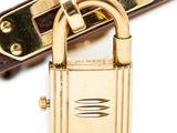 a gold padlock and a brown belt on a white surface