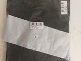 black and white t - shirt in plastic bag on white surface