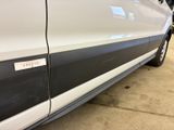 a white van with a black stripe parked in a garage