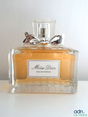 un flacon de parfum orné d'un nœud, posé sur une table