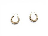 une paire de boucles d'oreilles en or sur fond blanc
