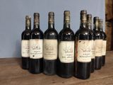 six bottles of wine are lined up on a wooden table