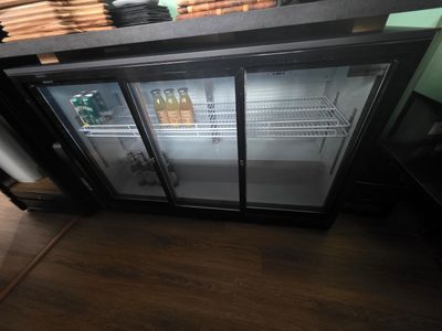un réfrigérateur à deux portes ouvert sur un parquet
