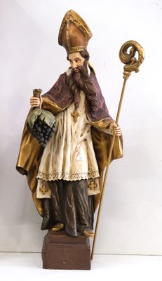 figurine représentant un homme coiffé d'un chapeau et vêtu d'une robe, tenant une canne