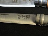 a knife that is sitting next to a knife on a table