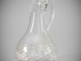 a clear glass pitcher with a handle on a table