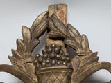 a gold vase with a bunch of grapes in it