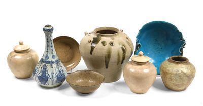 un ensemble de vases et de bols posés sur une surface blanche