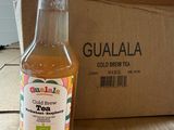 a bottle of tea sitting next to a box on the floor