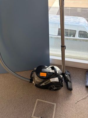 un aspirateur posé par terre près d'une fenêtre