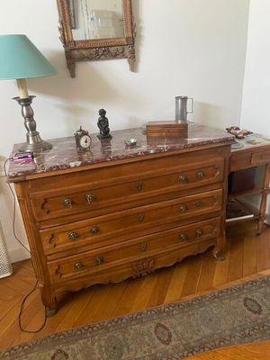 une commode avec un plateau en marbre sur lequel est posée une lampe