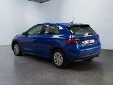 the rear of a blue car is parked in a room