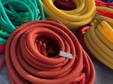 many different colored hoses sitting on the ground