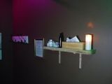 a small shelf with a candle and some pictures on it