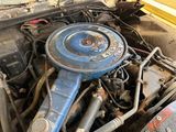 a blue engine in the engine bay of an old car