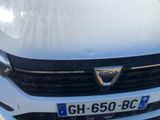 the front end of a white car with a number plate on it