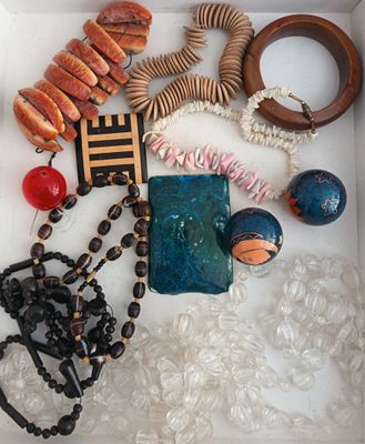 une boîte blanche remplie d'un assortiment de bijoux et de perles