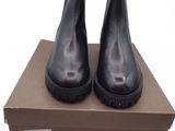 des bottines en cuir noir à semelles en caoutchouc, présentées dans une boîte