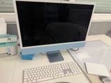 a computer monitor sitting on a desk with a keyboard and mouse