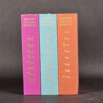 trois livres sont empilés sur une table