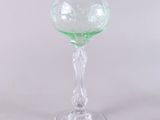 green glass goblet sitting on top of a white table
