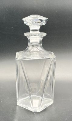 clear glass bottle with a diamond shaped top sitting on a table