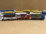 Plusieurs camions miniatures sont alignés en rang sur une table