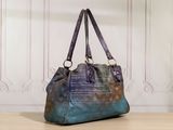 purple and blue handbag with writing on it sitting on a wooden table